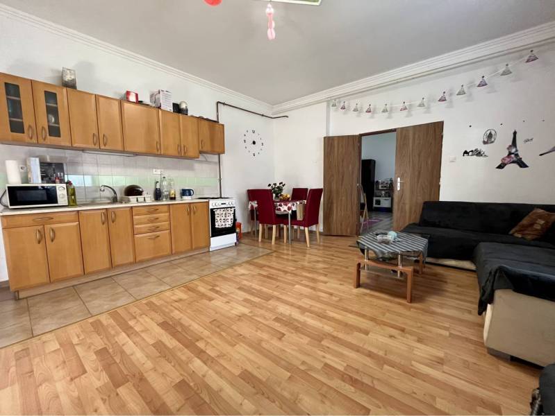 ZNÍŽENÁ CENA!!! Apartmánový dom na predaj vo Veľkom Mederi - Kuchyňa s jedálenským stolom v rodinnom dome, podlaha s dreveným dekorom, rozkladacia sedačka.