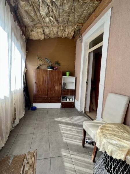 ZNÍŽENÁ CENA!!! Apartmánový dom na predaj vo Veľkom Mederi - Interiér rodinného domu s podlahou z dlaždíc, policou, kreslom a izbovými rastlinami.