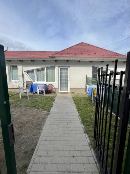 ZNÍŽENÁ CENA!!! Apartmánový dom na predaj vo Veľkom Mederi - Rodinný dom vo Veľkom Mederi s červenou strechou, trávnikom a vonkajším posedením.