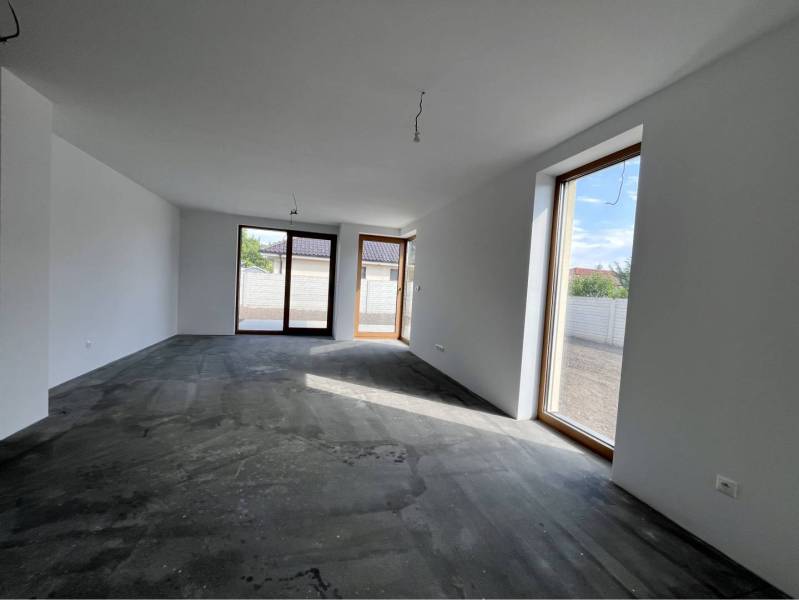 Jedinečný 5 izbový dom na predaj v TOP lokalite-GARDEN TOWN - Interiér rodinného domu s veľkými oknami a betónovou podlahou.