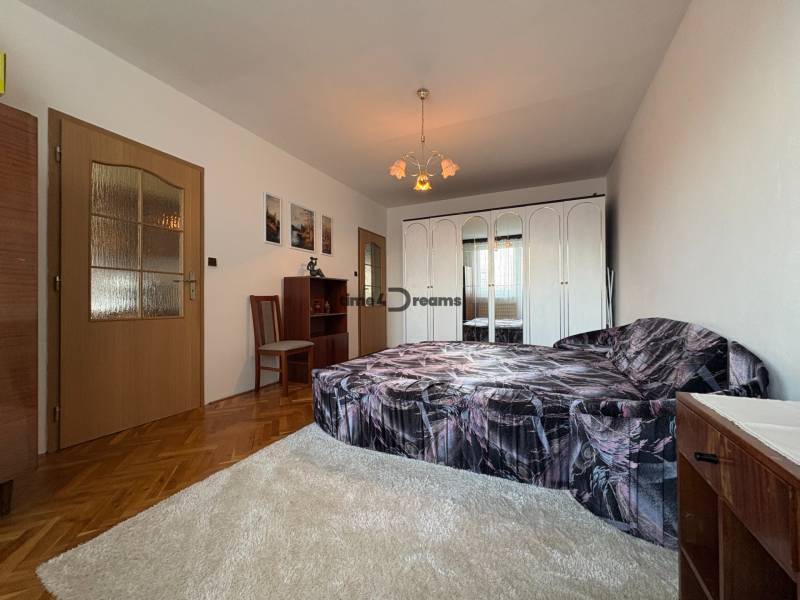 Na predaj: CENTRUM veľký 3 izb.byt + BALKON + ŠATNIK - Spálňa s posteľou, šatníkovou skriňou a nábytkom v 3-izbovom byte, drevené podlahy.