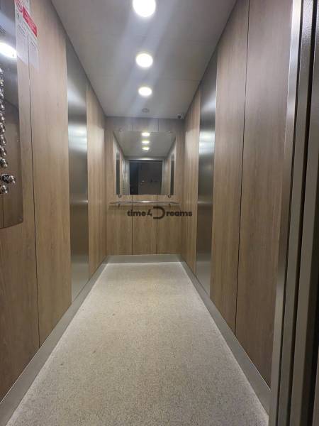 Na predaj: CENTRUM veľký 3 izb.byt + BALKON + ŠATNIK - Chodba so zrkadlom, drevenými stenami a osvetlením, súčasť trojizbového bytu.