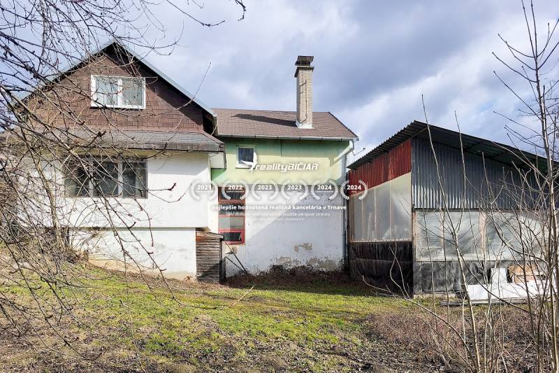 4-izbový rodinný dom s nebytovým priestorom v obci Pavlice - Rodinný dom v meste Pavlice na ulici Pavlice s plechovou prístavbou a trávnikom.