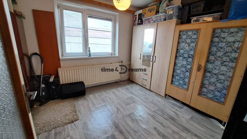 NA PREDAJ 6 izbový rodinný dom v obci Hrušovany  - Izba v rodinnom dome s podlahou s dreveným dekorom, vstavanými skriňami a oknom.