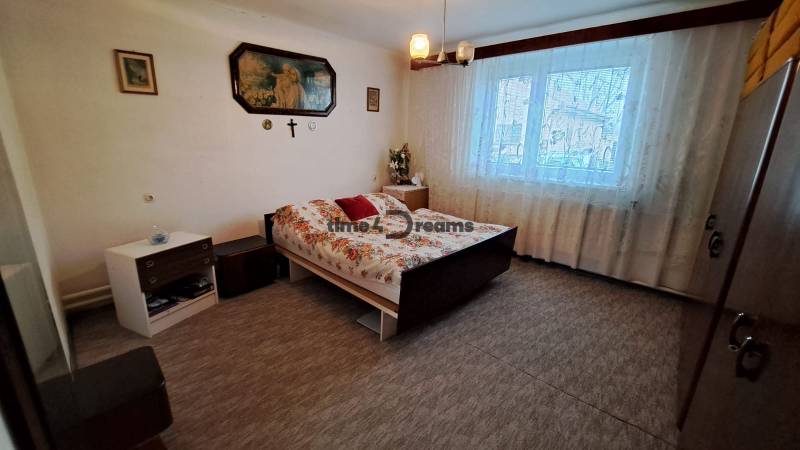 NA PREDAJ 6 izbový rodinný dom v obci Hrušovany  - Spálňa v rodinnom dome s posteľou, záclonami a nástennými dekoráciami.