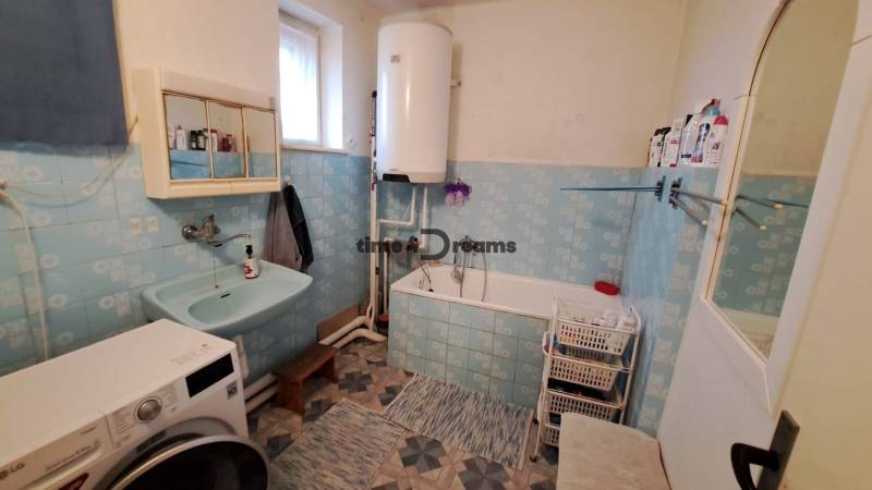 NA PREDAJ 6 izbový rodinný dom v obci Hrušovany  - Kúpeľňa v rodinnom dome s umývadlom, vaňou a práčkou. Modré obklady, úložné koše.