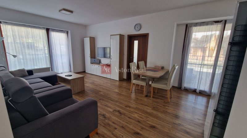 Rekreačný apartmán Vys. Tatry- HREBIENOK RESORT I. - 92 m2 -3-izbový - Obývacia izba Rekreačného apartmánu s podlahou s dreveným dekorom a priestrannou sedačkou.