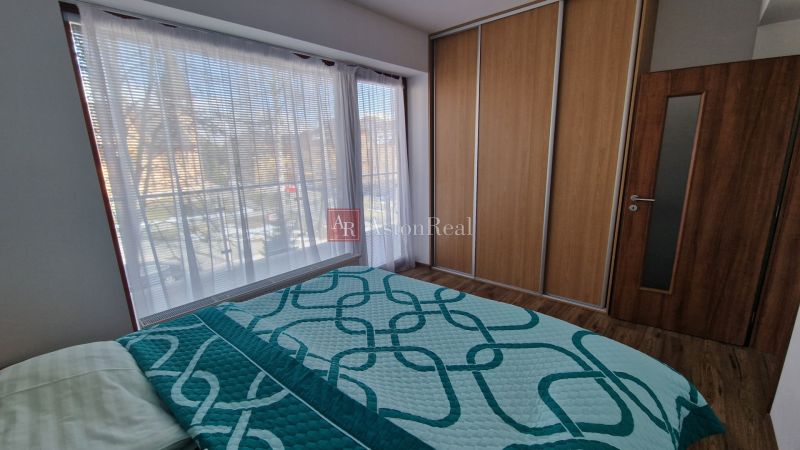 Rekreačný apartmán Vys. Tatry- HREBIENOK RESORT I. - 92 m2 -3-izbový - Spálňa v rekreačnom apartmáne s veľkými oknami a posteľou, podlaha s dreveným dekorom.