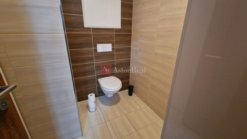 Rekreačný apartmán Vys. Tatry- HREBIENOK RESORT I. - 92 m2 -3-izbový - Toaleta Rekreačného apartmánu s obkladom v drevenom dekore a béžových tónoch.