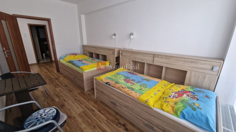 Rekreačný apartmán Vys. Tatry- HREBIENOK RESORT I. - 92 m2 -3-izbový - Detská izba v rekreačnom apartmáne s dvoma posteľami a podlahou s dreveným dekorom.