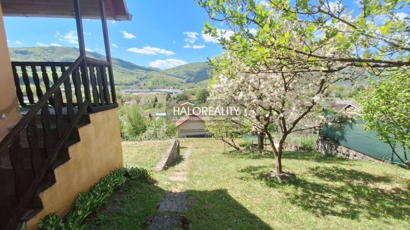 Predaj, chata Revúca - EXKLUZÍVNE HALO REALITY - Chata v Revúci obklopená rozkvitnutými stromami a scenériou hôr v pozadí.