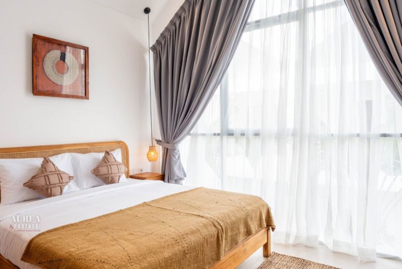 PREDAJ 3KK Investičná zariadená vila s bazénom BALI-Canggu Padonan - Svetlá spálňa vo Vile s veľkým oknom, bielou posteľou a závesmi.