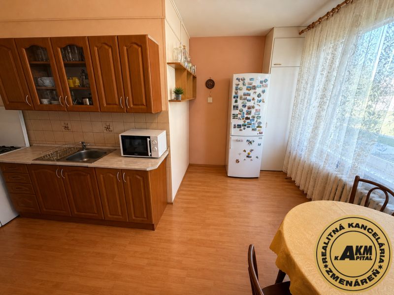  3 izbový byt s balkónom 75m2 Zvolen - Západ - Kuchyňa v 3-izbovom byte s podlahou s dreveným dekorom a jedálenským kútom.