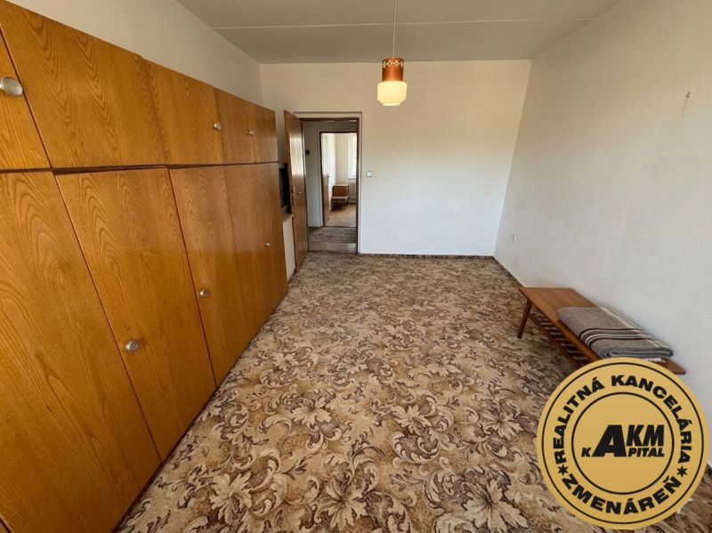  3 izbový byt s balkónom 75m2 Zvolen - Západ - Izba s kobercom, drevenými skriňami a stolíkom, 3-izbový byt.