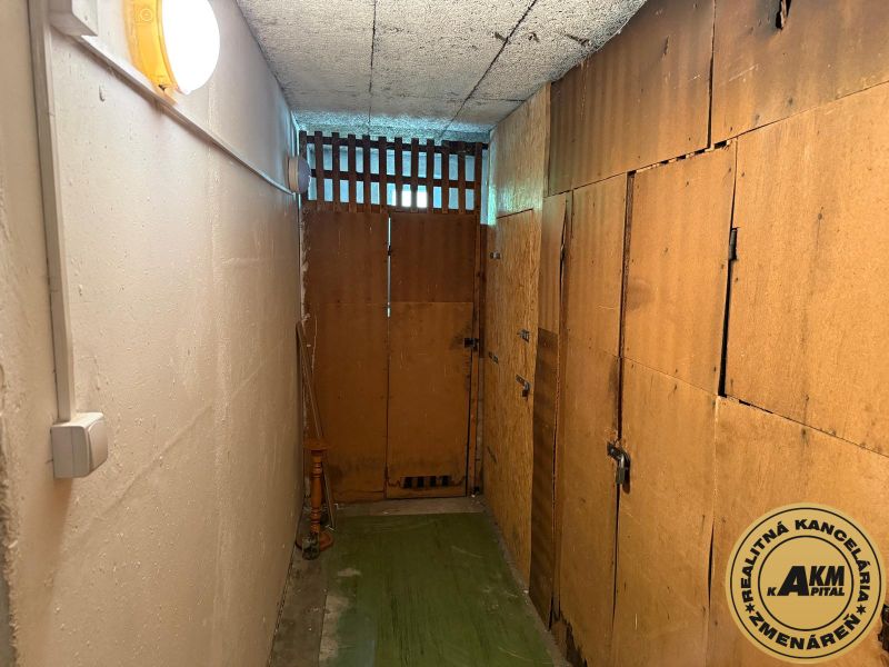  3 izbový byt s balkónom 75m2 Zvolen - Západ - Úzky pivničný priestor s drevenými dverami a osvetlením.