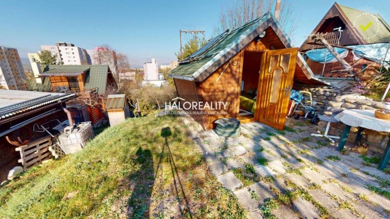Predaj, záhradná chata Liptovský Mikuláš, Podbreziny... - Záhrady v Liptovskom Mikuláši s drevenou chatkou obklopené zeleňou, v pozadí budovy.