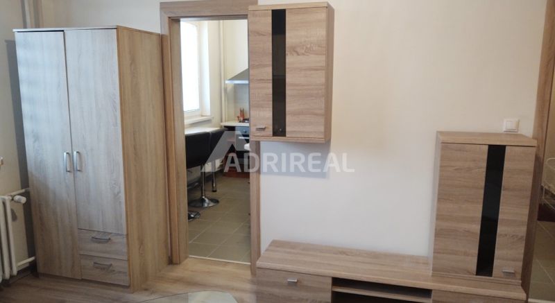 PREDAJ: 1i byt rekonš.; 34,51 m2; KEŽMAROK; 96.000€ - Interiér 1-izbového bytu s nábytkom v dekoru dreva a prístupom do kuchyne.