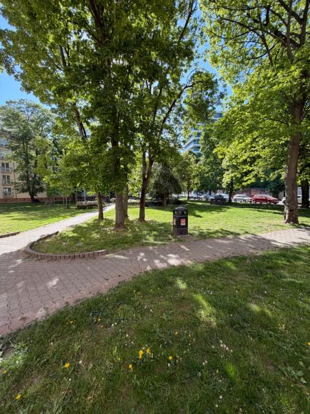 Na predaj 1.izbový byt v širšom centre mesta pri trhovisku. - Park v Bratislave-Ružinove s chodníkom, odpadkovým košom a stromami.