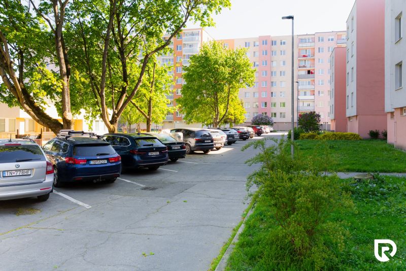 Na predaj garsónka 34m2 v Trenčíne na Ul. Opatovská - Parkovisko s autami medzi bytovkami na Opatovskej 651/33 v Trenčíne.