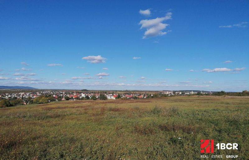 INVESTIČNÝ POZEMOK, ŠENKVICE - Šenkvice obklopené poľnohospodárskymi a lesnými pozemkami pod jasnou modrou oblohou.