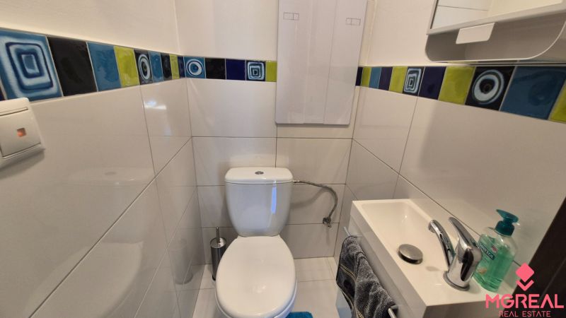 Prenájom 2izbový byt Topoľčany  - Kúpeľňa v 2-izbovom byte s bielymi obkladmi a farebným pásom dlaždíc.
