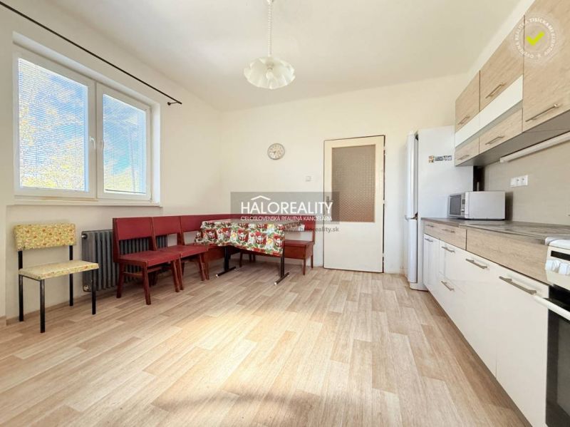 Predaj, rodinný dom Lipová, 3-izbový - Jasná kuchyňa v rodinnom dome s podlahou s dreveným dekorom, veľkými oknami a nábytkom.
