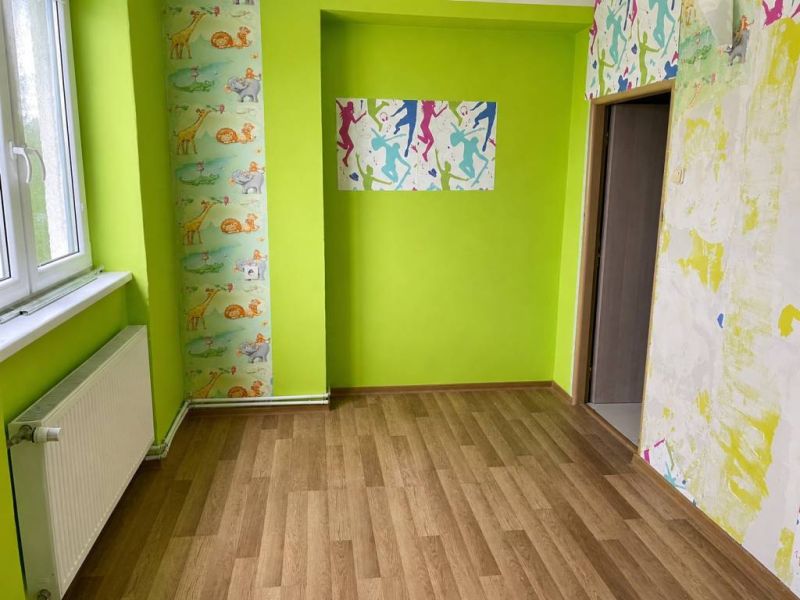 3-izbový byt v Hrnčiarskej Vsi – balkón, pivnica a dostupná cena - Detská izba so svetlou stenou, farebnými tapetami a podlahou s dreveným dekorom.