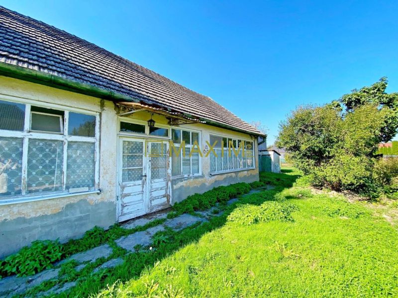 Exkluzívna šanca! Stavebný pozemok vo Vlčanoch, len na skok od Šale. - Vo Vlčanoch sa nachádza rodinný dom so staršími oknami a záhradou.