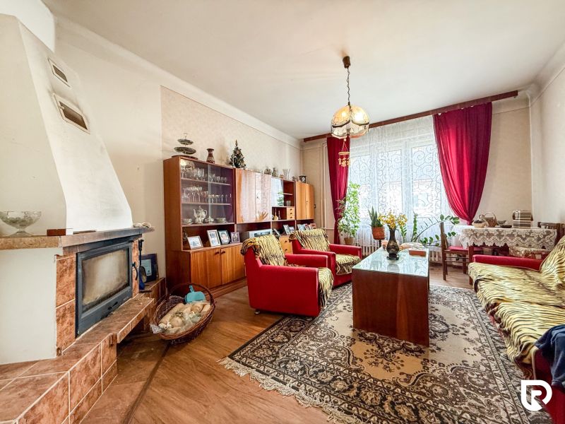 Rodinný dom s pozemkom 727m2, Tatranská ul. - Trenčín - Obývačka v rodinnom dome s krbom a podlahou s dreveným dekorom, zariadená starožitným nábytkom.