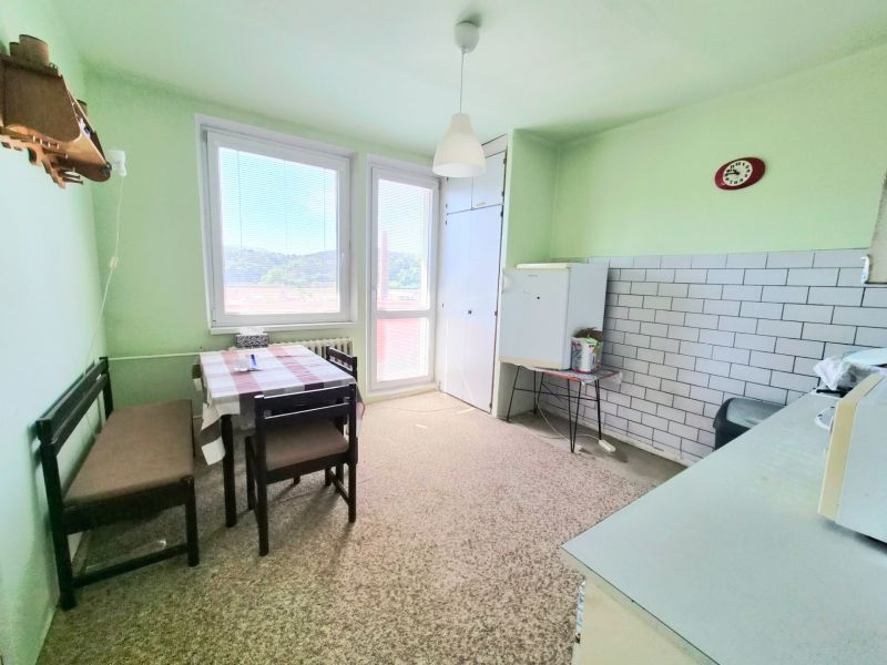 3 izbový byt 77m2 s balkónom Trenčín - Kubrá  - Kuchyňa v 3-izbovom byte s jedálenským stolom, zelené steny, a kachličkovou stenou.