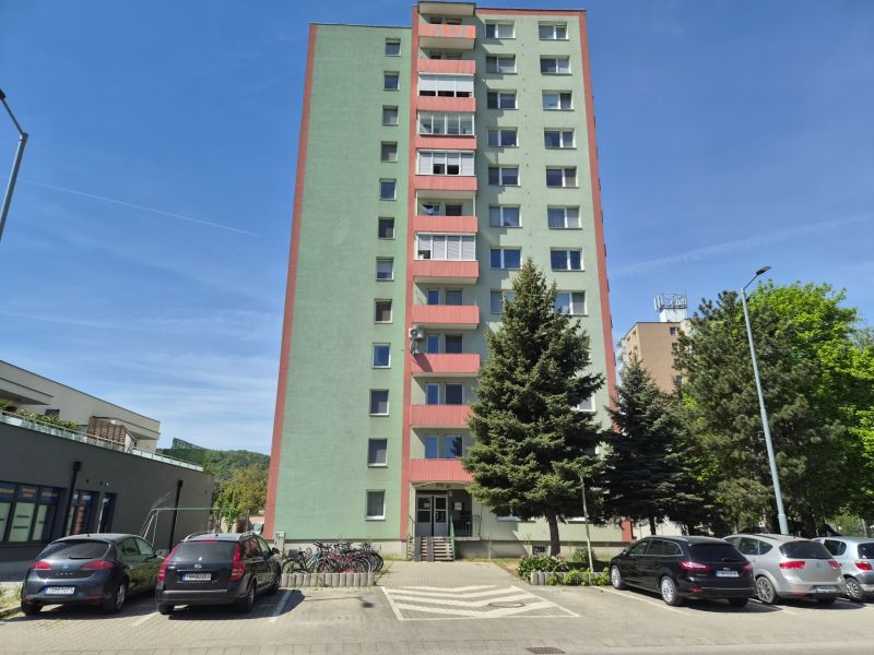 3 izbový byt 77m2 s balkónom Trenčín - Kubrá  - Bytový dom v Trenčíne na ulici Pred poľom, vedľa neho zaparkované autá.