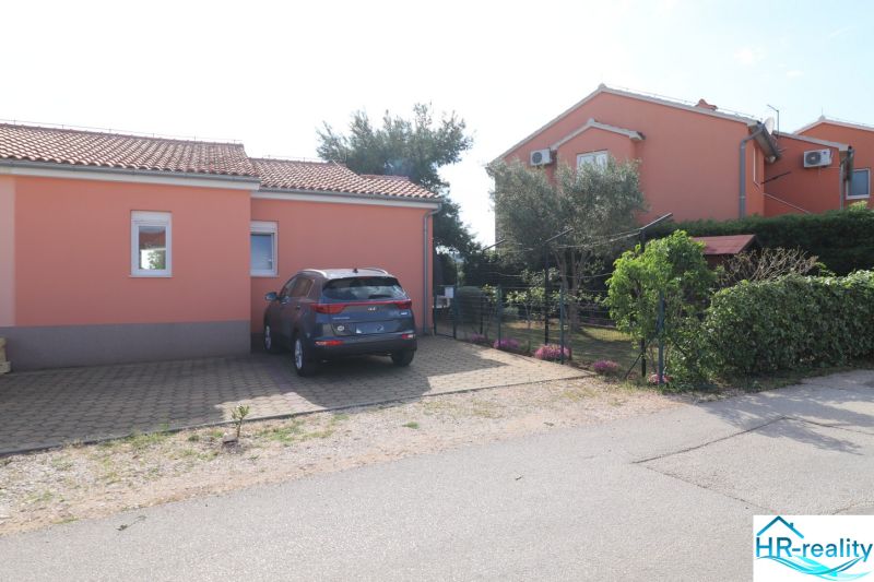 Chorvátsko, Vodice - zariadený bungalov, výhľad na more - Rodinný dom v meste Vodice, parkovacie miesto a záhrada s kvetmi a stromami.
