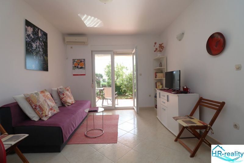 Chorvátsko, Vodice - zariadený bungalov, výhľad na more - Interiér rodinného domu s pohovkou, televíziou a výhľadom do záhrady.