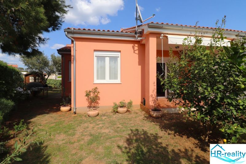 Chorvátsko, Vodice - zariadený bungalov, výhľad na more - Rodinný dom vo Vodiciach s terakotovou strechou, okolitou zeleňou a kvetináčmi v záhrade.