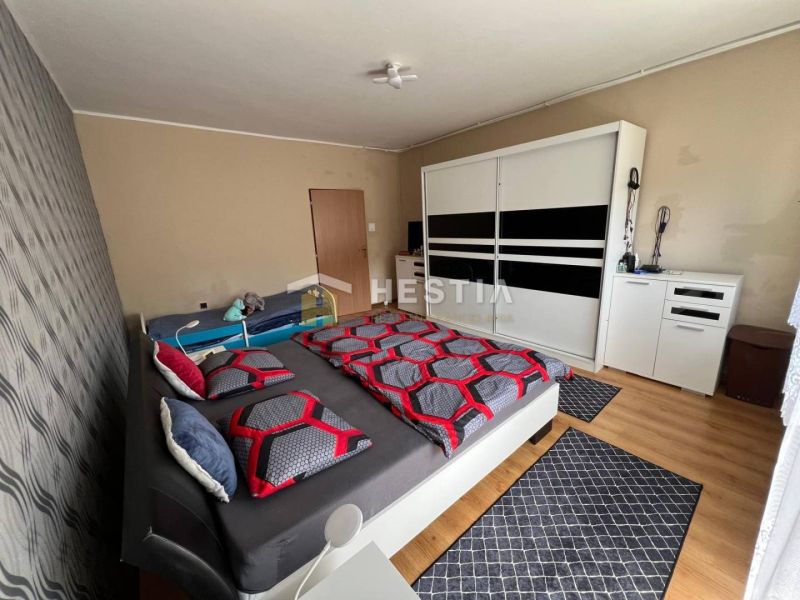 NOVINKA Priestranný 3-izbový byt (99 m²) s pozemkom, terasou, 2 balkón - Spálňa v 3-izbovom byte s veľkou skriňou a podlahou s dreveným dekorom.
