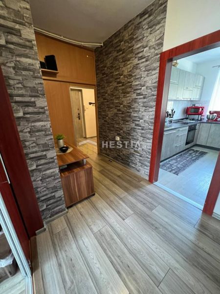 NOVINKA Priestranný 3-izbový byt (99 m²) s pozemkom, terasou, 2 balkón - Chodba 3-izbového bytu s podlahou s dreveným dekorom a kameňom obloženými stenami.