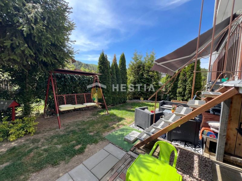 NOVINKA Priestranný 3-izbový byt (99 m²) s pozemkom, terasou, 2 balkón - Záhrada s hojdačkou a ratanovým sedením pri 3-izbovom byte v Brezovej pod Bradlom.
