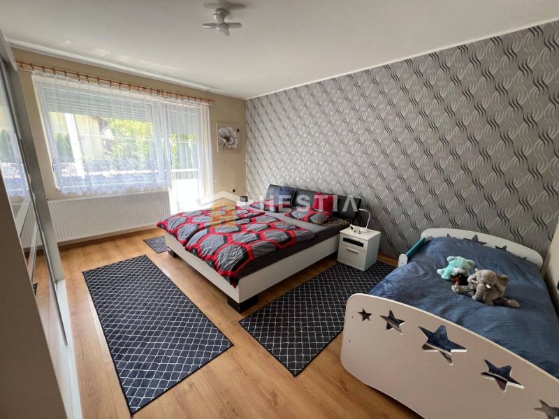 NOVINKA Priestranný 3-izbový byt (99 m²) s pozemkom, terasou, 2 balkón - Spálňa s dvojposteľou, detskou posteľou a podlahou s dreveným dekorom v 3-izbovom byte.