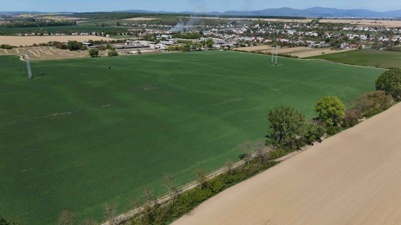 Trhovište – 5.894 m2 POZEMOK na mobilný dom so stavebným potenciálom  - Rozľahlé zelené polia a Trhovište v pozadí, Rekreačné pozemky v okolí.