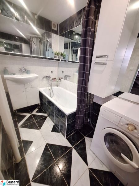NA PRENÁJOM 1 IZBOVÝ TEHLOVÝ BYT, 34 M2, KOŠICE - ŠACA - Kúpeľňa s čiernobielymi dlaždicami, umývadlom, vaňou a práčkou v 1-izbovom byte.