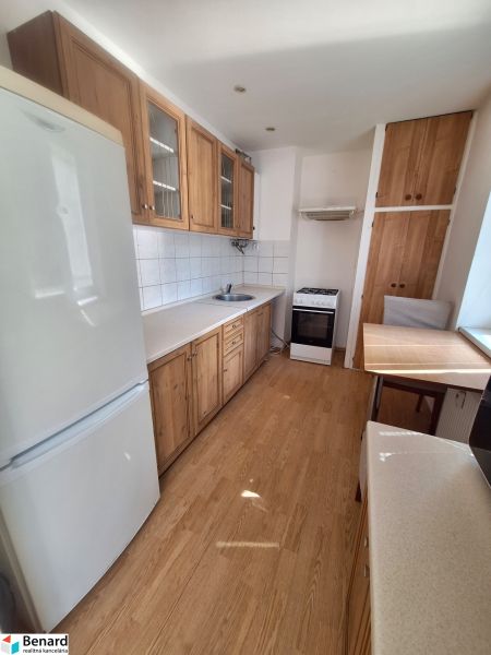 NA PRENÁJOM 1 IZBOVÝ TEHLOVÝ BYT, 34 M2, KOŠICE - ŠACA - Kuchyňa v 1-izbovom byte s bielymi stenami, podlahou s dreveným dekorom a spotrebičmi.