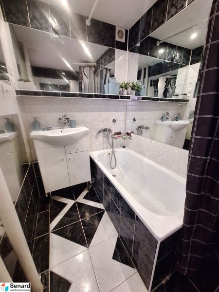 NA PRENÁJOM 1 IZBOVÝ TEHLOVÝ BYT, 34 M2, KOŠICE - ŠACA - Kúpeľňa v 1-izbovom byte s vaňou, umývadlom a tmavým obkladom.