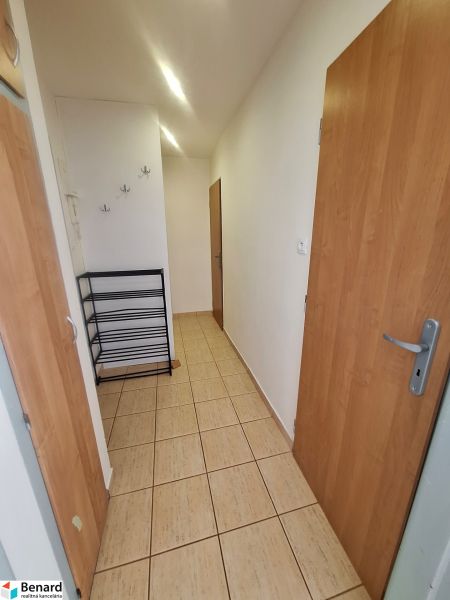 NA PRENÁJOM 1 IZBOVÝ TEHLOVÝ BYT, 34 M2, KOŠICE - ŠACA - Chodba v 1-izbovom byte s dverami a vešiakmi na stene.