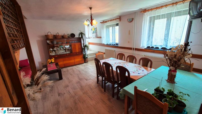 2 PODLAŽNÝ RODINNÝ DOM S PRÍSTAVBOU, 1064m2, JARABINA; - Interiér rodinného domu s jedálenským stolom, príborníkom a podlahou s dreveným dekorom.