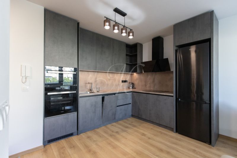 Moderný 2-izbový byt s balkónom, Ovocné sady - Kuchyňa v 2-izbovom byte s antracitovými skriňami a podlahou s dreveným dekorom.