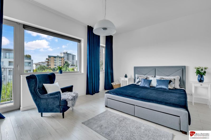 Predaj, Luxusný 4 izbový byt, 180 m2 + 25 m2, Condominium Renaissance - Svetlá spálňa v 4-izbovom byte s veľkým oknom, modrými závesmi a pohodlným kreslom.