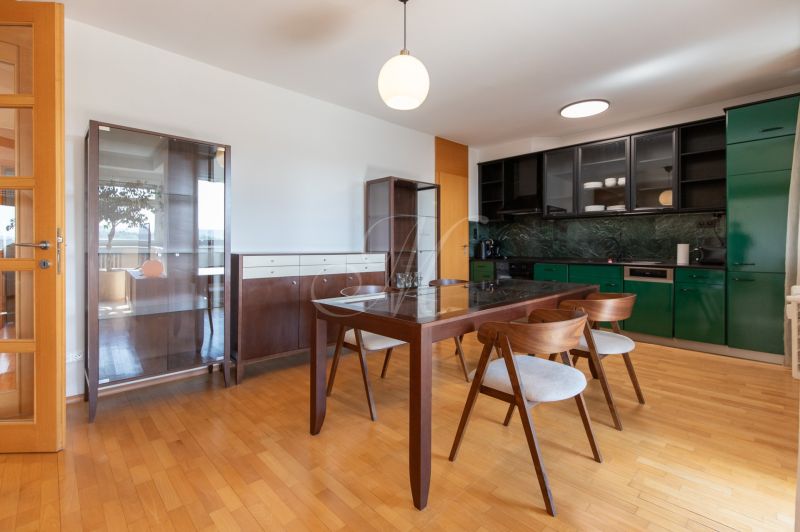 Zariadený 4-izbový byt s balkónmi a parkovaním - Jedálenský kút v 4-izbovom byte s moderným nábytkom a podlahou s dreveným dekorom.