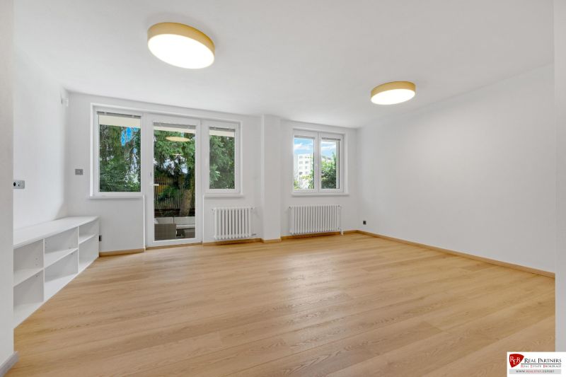 ,Prenájom moderný 3 izb. byt, Sološnícka ul,124 m2, Karlova Ves - Obývacia izba s podlahou s dreveným dekorom v rodinnom dome, presvetlená izbovými oknami.