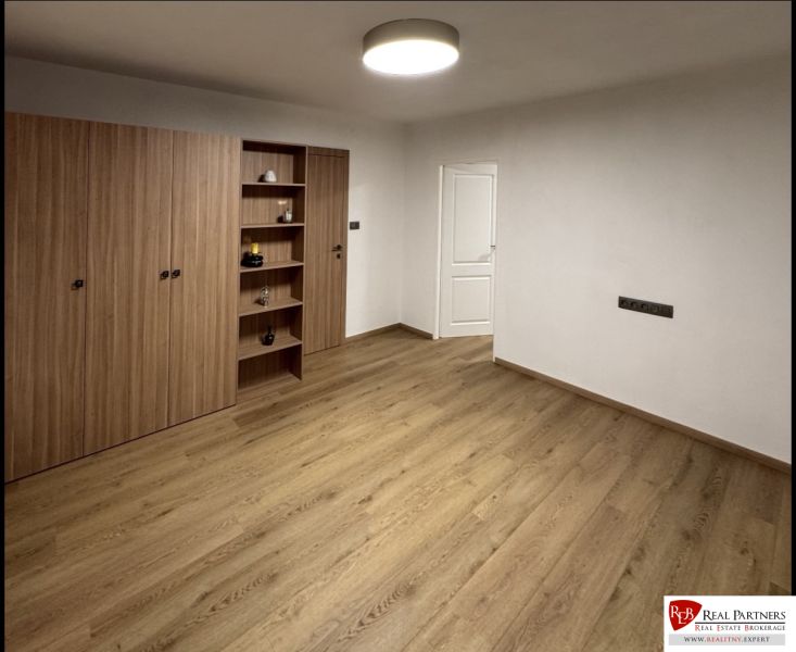 ,Prenájom moderný 3 izb. byt, Sološnícka ul,124 m2, Karlova Ves - Izba v 3-izbovom byte s podlahou s dreveným dekorom a vstavanými skriňami.