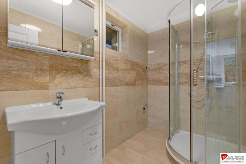 ,Prenájom moderný 3 izb. byt, Sološnícka ul,124 m2, Karlova Ves - Kúpeľňa v rodinnom dome s vaňou a umývadlom, obložená svetlými dlaždicami.